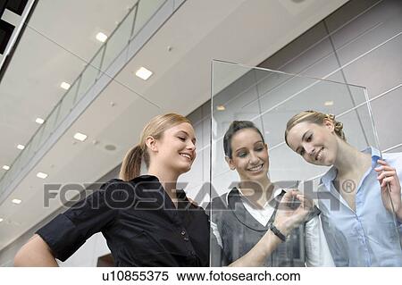 Stock Photography - Young businesswoman writing on glass. Fotosearch