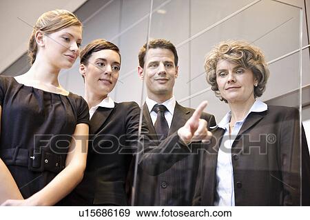 Stock Photo - Young businesswomen writing on glass. Fotosearch