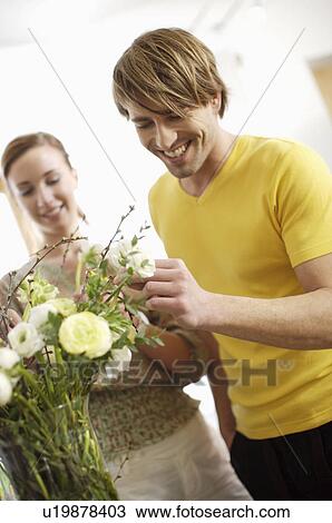 Stock Image - Young couple arranging flowers. Fotosearch