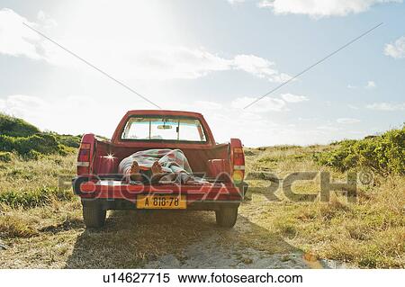 Stock Photography - Young couple asleep in back of truck. Fotosearch