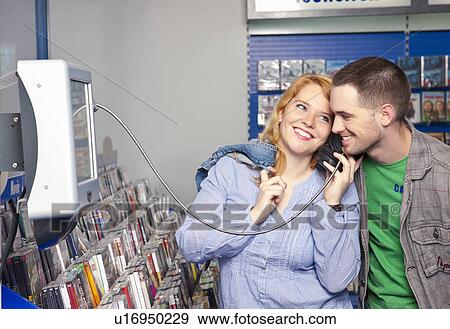 Stock Photo - Young couple checking new music. Fotosearch