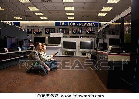 Young couple checking TV View Large Photo Image Stock Image - Young couple checking TV. Fotosearch