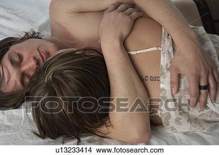 Young couple embracing in bed View Large Photo Image Picture - Young couple embracing in bed. Fotosearch