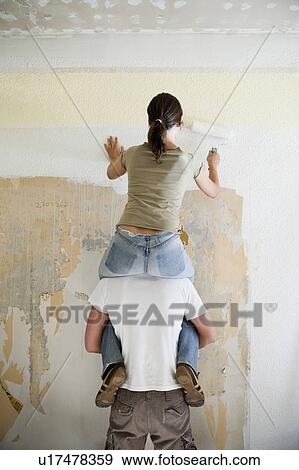 Stock Photo - Young couple painting wall. Fotosearch
