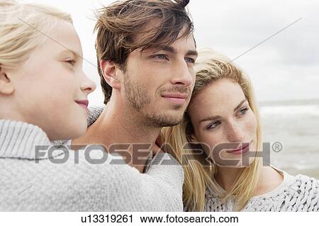 Stock Image - Young family on beach in autumn. Fotosearch