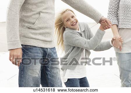 Stock Photo - Young family on beach in autumn. Fotosearch