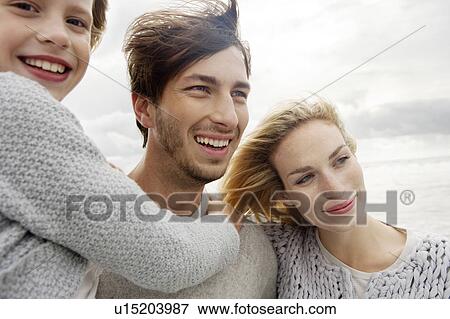 Stock Photo - Young family on beach in autumn. Fotosearch