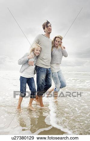 Stock Photo - Young family on beach in autumn. Fotosearch