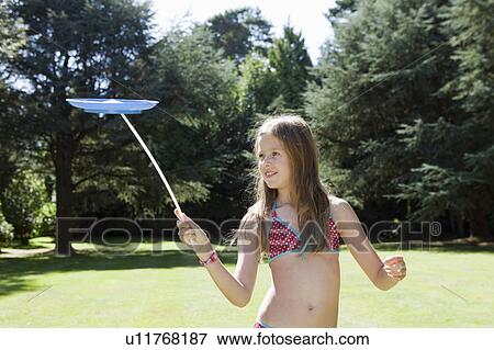 Stock Photo - Young girl balancing a plate on stick. Fotosearch