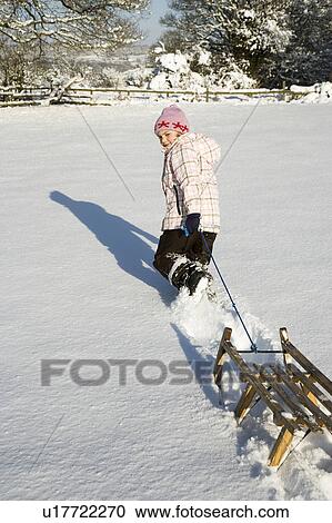 Young girl pulling sledge in snow View Large Photo Image Stock Image - Young girl pulling sledge in snow. Fotosearch