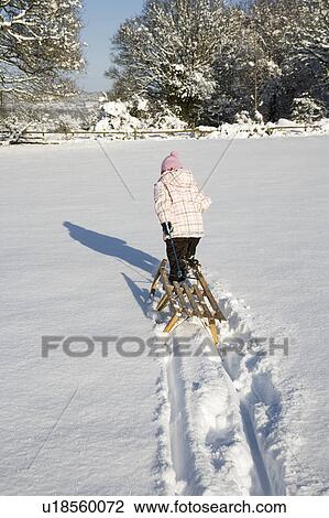 Young girl pulling sledge in snow View Large Photo Image Stock Image - Young girl pulling sledge in snow. Fotosearch