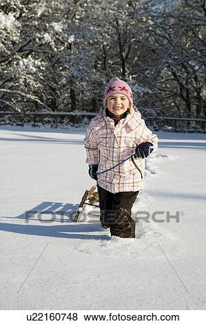 Young girl pulling sledge in snow View Large Photo Image Stock Photo - Young girl pulling sledge in snow. Fotosearch