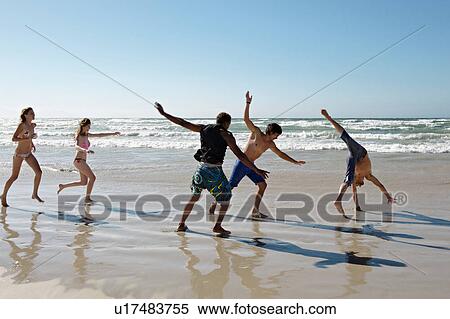Young group frolicking on beach View Large Photo Image Stock Photography - Young group frolicking on beach. Fotosearch
