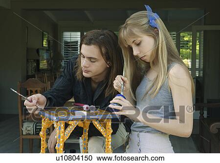Young man and woman painting table View Large Photo Image Stock Image - Young man and woman painting table. Fotosearch