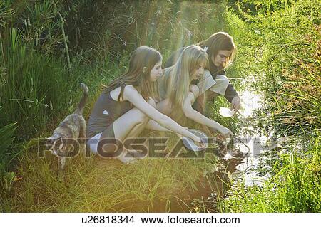 Young man and women catching tadpoles View Large Photo Image Picture - Young man and women catching tadpoles. Fotosearch