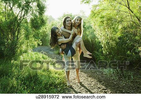 Young man carrying two young women View Large Photo Image Stock Image - Young man carrying two young women. Fotosearch