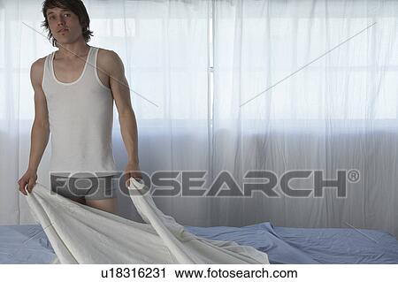 Young man in underwear making bed View Large Photo Image Stock Image - Young man in underwear making bed. Fotosearch