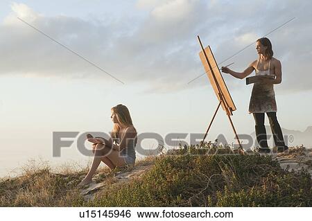 Stock Photograph - Young man painting with young woman. Fotosearch