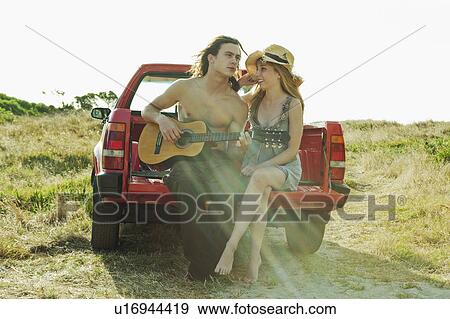 Young man playing guitar to young woman View Large Photo Image Stock Photo - Young man playing guitar to young woman. Fotosearch