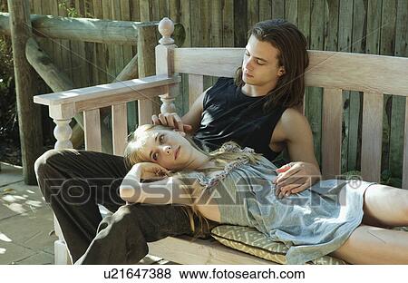 Stock Photo - Young man stroking young womans ear. Fotosearch