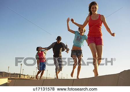 Stock Photo - Young people balancing on wall. Fotosearch