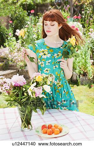 young woman arranging flowers in vase. View Large Photo Image Stock Image - young woman arranging flowers in vase.. Fotosearch