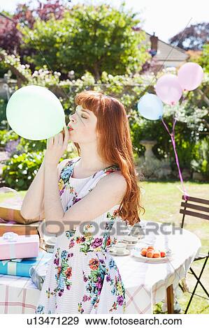 young woman blows up balloon. View Large Photo Image Stock Photo - young woman blows up balloon.. Fotosearch