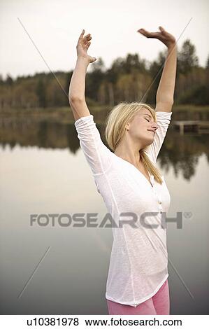 Young woman dancing by lake, stretching View Large Photo Image Stock Photo - Young woman dancing by lake, stretching. Fotosearch
