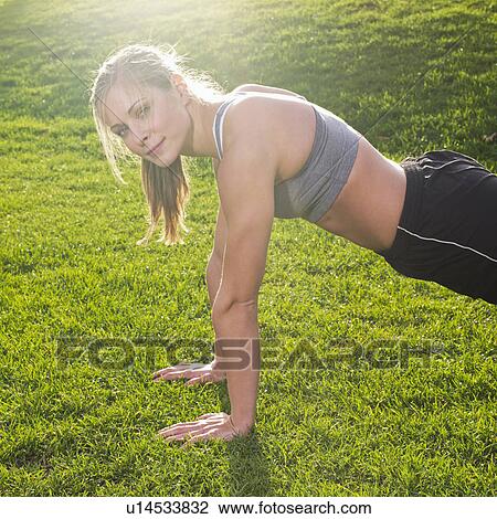 Young woman doing push ups View Large Photo Image Stock Image - Young woman doing push ups. Fotosearch