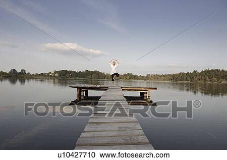 Stock Image - Young woman doing yoga exercise. Fotosearch