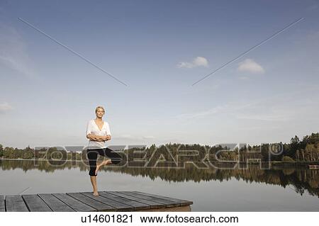 Stock Image - Young woman doing yoga exercise. Fotosearch