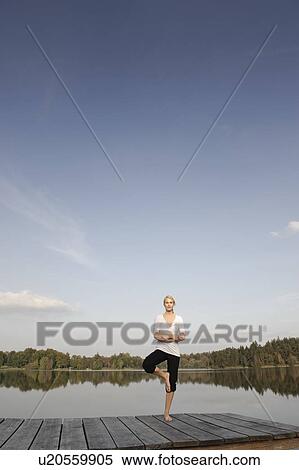 Young woman doing yoga exercise View Large Photo Image Stock Photography - Young woman doing yoga exercise. Fotosearch