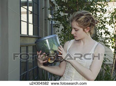 Stock Image - Young woman holding vegetable waste. Fotosearch
