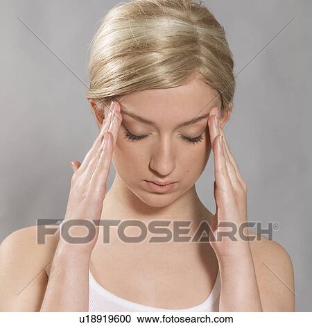 Young woman is touching her temples View Large Photo Image Stock Image - Young woman is touching her temples. Fotosearch