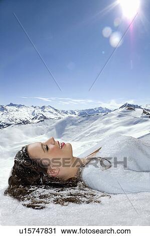 Young woman lays in snow View Large Photo Image Stock Image - Young woman lays in snow. Fotosearch