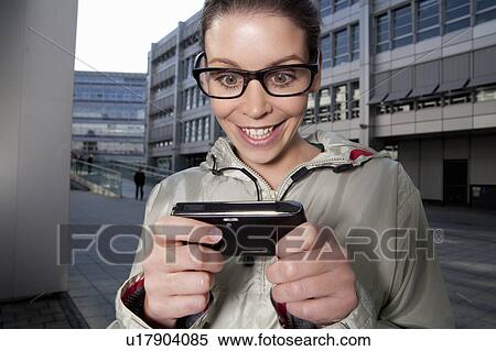 Stock Photography - Young woman looking at her mobile. Fotosearch