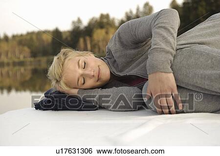Young woman lying on blanket by lake View Large Photo Image Stock Photograph - Young woman lying on blanket by lake. Fotosearch