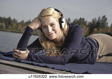 Young woman lying on blanket, smiling View Large Photo Image Stock Image - Young woman lying on blanket, smiling. Fotosearch
