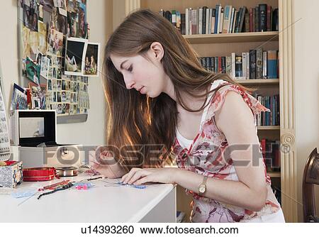 Stock Image - Young woman making jewelry. Fotosearch
