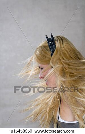 Stock Image - Young woman moves with headphones. Fotosearch