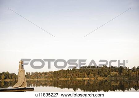 Young woman standing on jetty, enjoying View Large Photo Image Stock Photo - Young woman standing on jetty, enjoying. Fotosearch