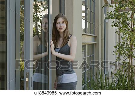Stock Photography - Young woman walking through door. Fotosearch