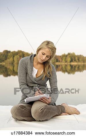 Young woman writing, sketching, by lake View Large Photo Image Picture - Young woman writing, sketching, by lake. Fotosearch