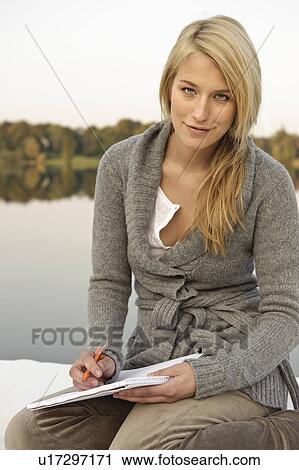 Young woman writing, sketching, by lake View Large Photo Image Stock Image - Young woman writing, sketching, by lake. Fotosearch