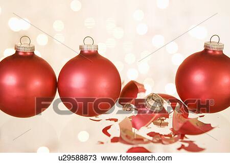 Stock Image - A broken christmas bauble between others. Fotosearch