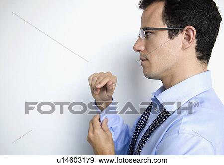 Stock Photo - A business man doing up his cuffs. Fotosearch