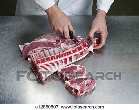 A butcher cutting a meat View Large Photo Image Stock Photo - A butcher cutting a meat. Fotosearch