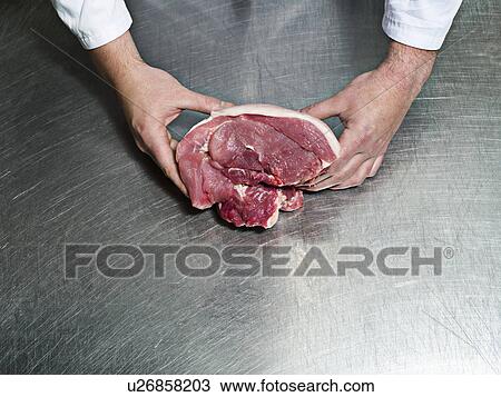 A butchers hands holding a piece of meat View Large Photo Image Stock Image - A butchers hands holding a piece of meat. Fotosearch