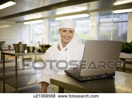 A chef working at her laptop View Large Photo Image Stock Photo - A chef working at her laptop. Fotosearch
