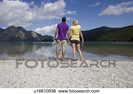 A couple standing by a lake View Large Photo Image Stock Photo - A couple standing by a lake. Fotosearch